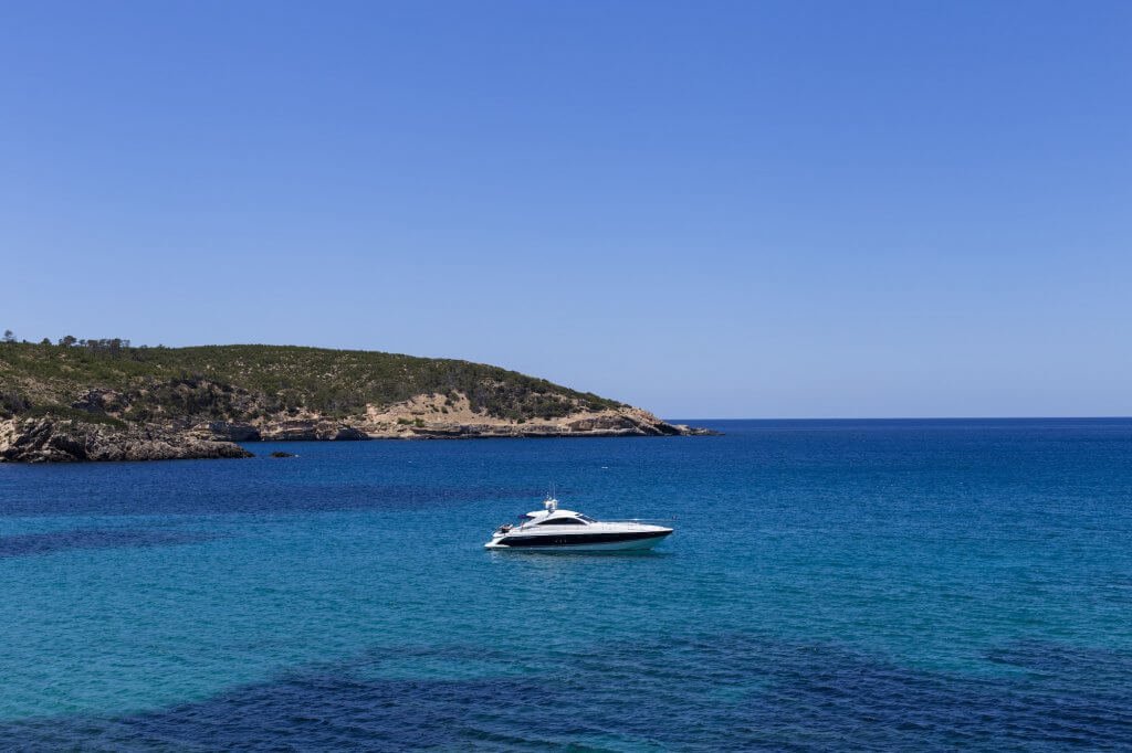beautiful landscape in Ibiza of blue ocean in a sunny day with boats in the horizon