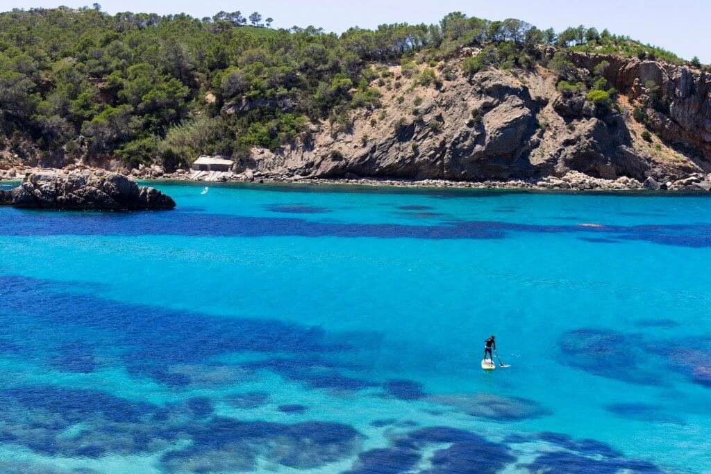 Man practicing paddle surf on Beautiful blue water in Ibiza