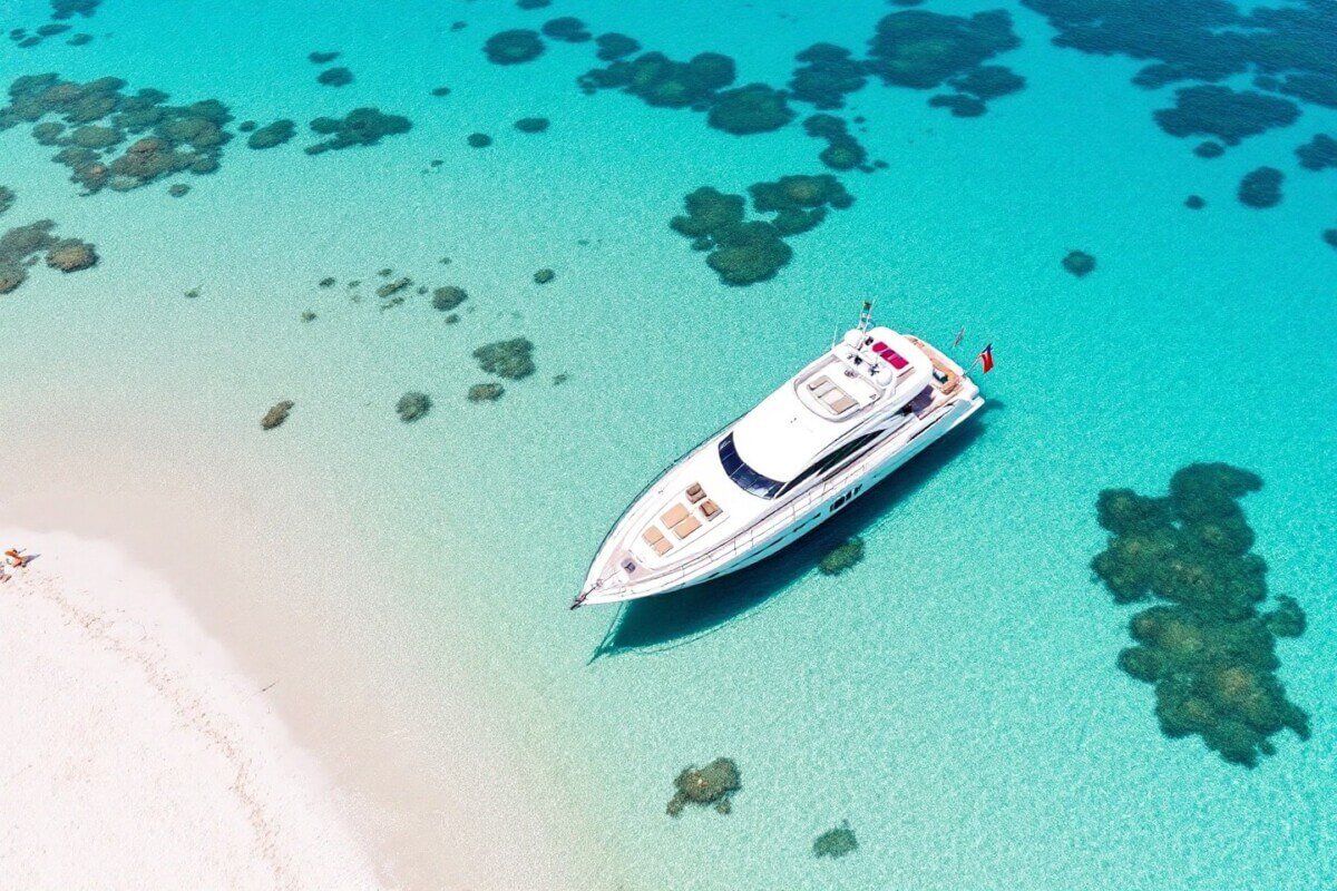 Yate de lujo fondeado en una de las mejores playas Formentera barco, con aguas cristalinas.
